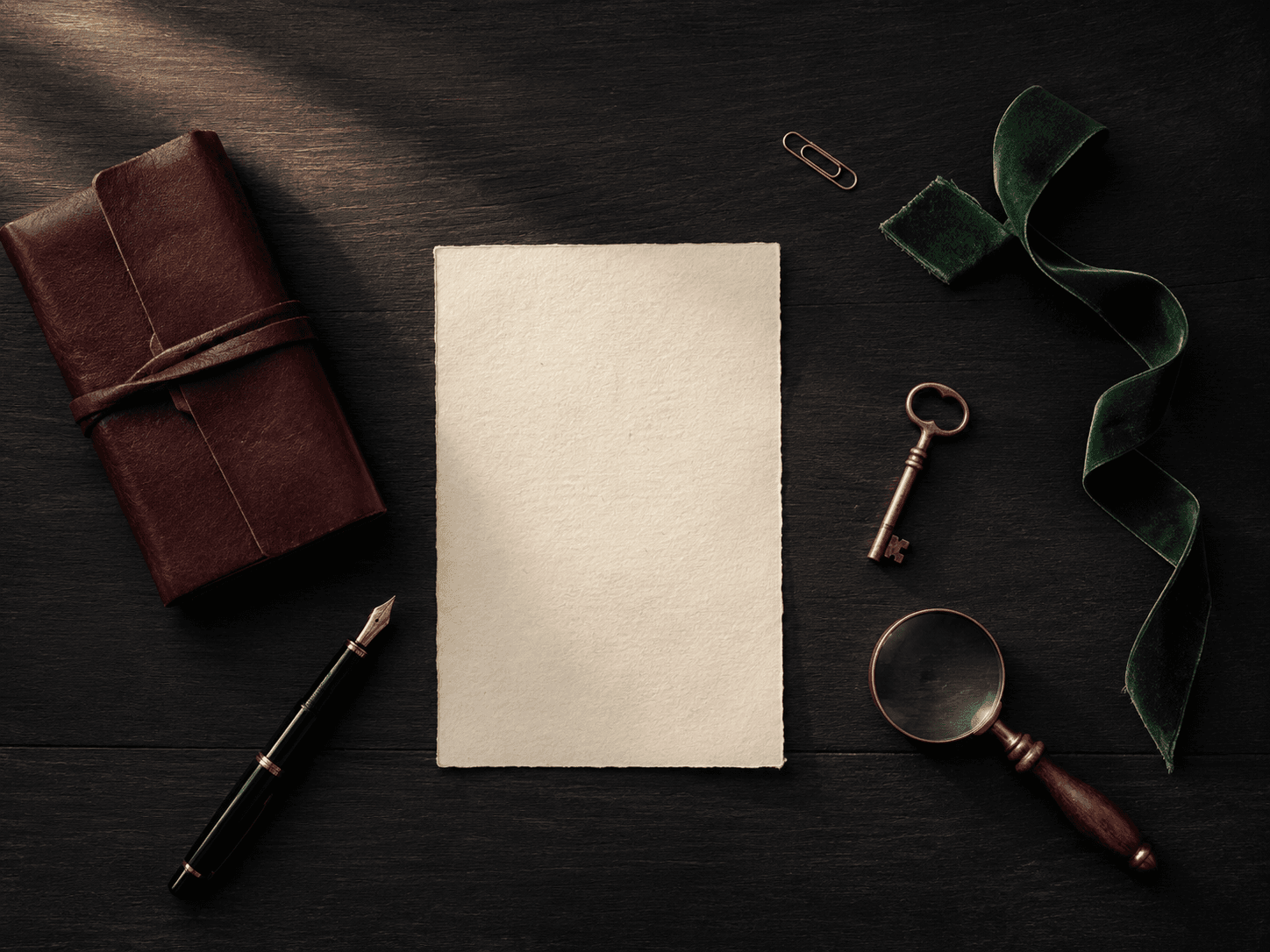 A case file, a brass key, and a magnifying glass on dark mahogany.